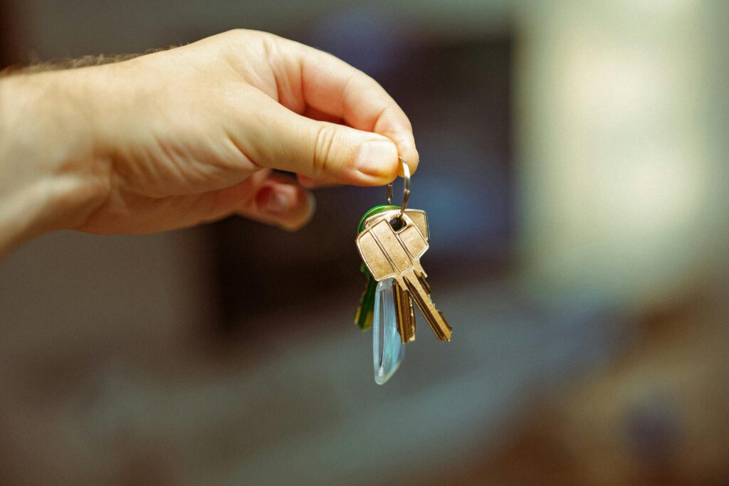 Hand holding keys to a new house. Real estate residential.